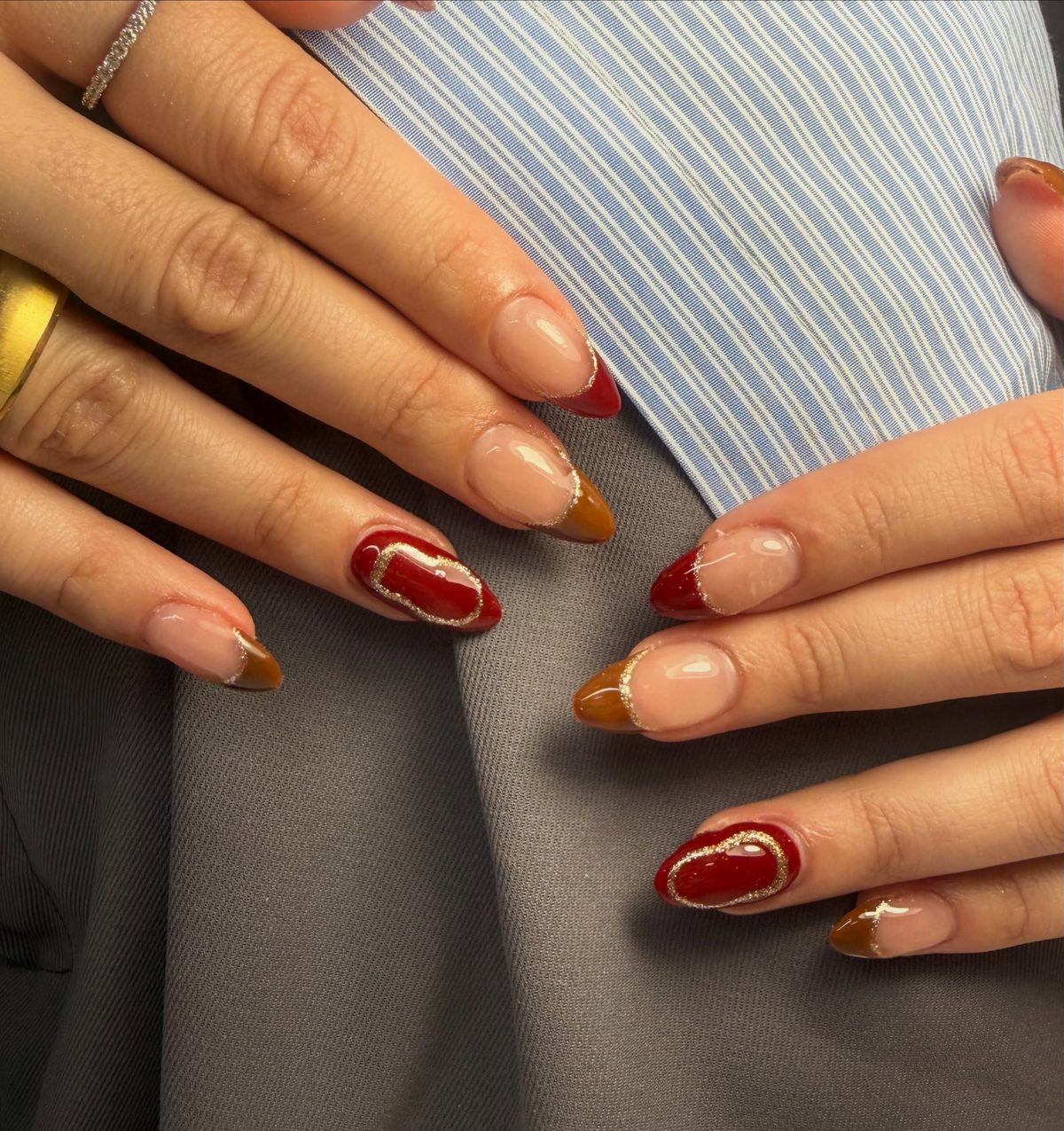 Fall manicure with red and caramel French tips and gold glitter detail at Lietynails